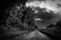 Menacing view of a rural dirt track lane showing storm clouds gathering. Royalty Free Stock Photo