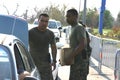 Military personnel load supplies into cars.