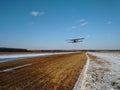 Takeoff of an old biplane plane from a winter airfield from a runway with grass with a blue sky background