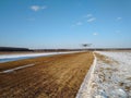 Takeoff of an old biplane plane from a winter airfield from a runway with grass with a blue sky background Royalty Free Stock Photo