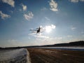 Takeoff of an old yellow biplane plane from a dirt runway in winter on a Sunny day and blue sky Royalty Free Stock Photo