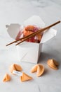 A takeout food container filled with fortune cookies with cookies in front. Royalty Free Stock Photo