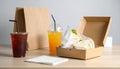 Takeout Lunch with Iced Drinks and Sandwich in Box on Wooden Table Royalty Free Stock Photo