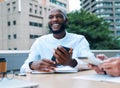 It takes dedication to make your dreams work. a young businessman using a cellphone during a meeting on the balcony of