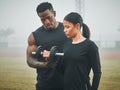 It takes hard work to maintain good form. a sporty young woman exercising with dumbbells with the help of a trainer Royalty Free Stock Photo