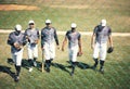 It takes a team to win a tournament. a group of young men walking onto a baseball field.