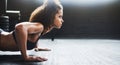 It takes work, but youre worth it. a young woman doing pushups in a gym.