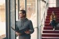 Taking in all the information. a handsome young university student studying while standing in a hallway on campus. Royalty Free Stock Photo