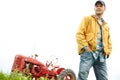 Taking in the beauty of my farm. a farmer standing in a field with a tractor parked behind him. Royalty Free Stock Photo