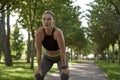 Taking a break. Beautiful fitness woman in sportswear getting tired, exhausted after morning workout in the city park