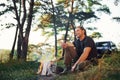 Taking a break. Man in black shirt near the campfire in the forest at his weekend time