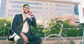 Taking a break from the office. a handsome young businessman taking a phone call while sitting down on some steps in the Royalty Free Stock Photo