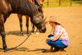 Cowgirl standing next to brown horse friend Royalty Free Stock Photo