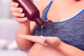 Pregnant woman applying body lotion on the hand. Royalty Free Stock Photo