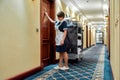 Taking care of your comfort. Full-length shot of hotel maid in uniform knocking on the door for room service while Royalty Free Stock Photo