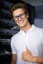 Taking care of your network needs. A happy computer technician in a server room giving you the thumbs up. Royalty Free Stock Photo