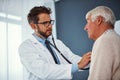 Taking a careful listen to his heart. a doctor examining a senior patient with a stethoscope in a clinic. Royalty Free Stock Photo