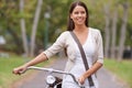 Taking in the City View. A beautiful young woman walking through a park with her bicycle. Royalty Free Stock Photo