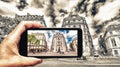 Taking colors out of black and white. Female hand with smartphone taking a picture of Paris. Tourism concept