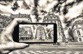 Taking colors out of black and white. Female hand with smartphone taking a picture of Paris. Tourism concept