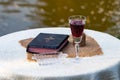 Taking Communion. Cup of glass with red wine, bread and Holy Bib Royalty Free Stock Photo