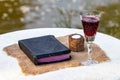 Taking Communion. Cup of glass with red wine, bread and Holy Bib Royalty Free Stock Photo