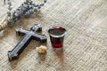 Taking communion with glass of wine and bread near cross