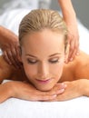 Taking a day to enjoy some pampering. A beautiful young woman relaxing in a spa - massage therapy. Royalty Free Stock Photo