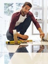 Taking on this DIY project one tile at a time. Portrait of a smiling man laying floor tiles. Royalty Free Stock Photo