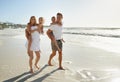 Taking a family beach stroll. Smiling parents carrying their son and daughter down the beach. Royalty Free Stock Photo