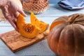 Taking freshly cut orange pumpkin slices by hand Royalty Free Stock Photo