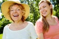 Taking a fun stroll in the park. A senior woman enjoying a relaxing stroll in the summer sun with her daughter. Royalty Free Stock Photo