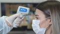 Taking a girl`s temperature with thermometer to find coronavirus, Covid-19. Close up shot. Royalty Free Stock Photo