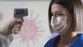 Taking a girl`s temperature with thermometer to find coronavirus, Covid-19. Close up shot. Royalty Free Stock Photo