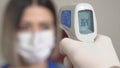 Taking a girl`s temperature with thermometer to find coronavirus, Covid-19. Close up shot. Royalty Free Stock Photo