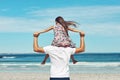 Taking a look at the horizon. Rearview shot of a young father and his daughter enjoying a day at the beach. Royalty Free Stock Photo