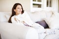 Taking a Me-Day...A thoughtful-looking and attractive woman lounging on a sofa indoors.