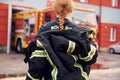 Taking off the protective clothes. Woman firefighter in uniform is at work in department Royalty Free Stock Photo