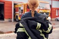 Taking off the protective clothes. Woman firefighter in uniform is at work in department Royalty Free Stock Photo