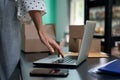 Taking orders online. Cropped shot of a woman, female business owner using laptop while standing in her shop or store Royalty Free Stock Photo