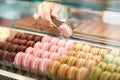 Taking out macaron from glass case