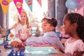 Funny boy smiling and taking party horn from the table Royalty Free Stock Photo