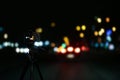 Taking photo of with camera mounted on tripod. Blurred view of city lights at night, bokeh effect Royalty Free Stock Photo