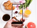 Taking photo of delicious breakfst with smartphone Royalty Free Stock Photo