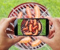 Taking photo of grilling sausages by smartphone.