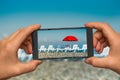 Taking photo of sunbathing beds and red umbrella with phone Royalty Free Stock Photo