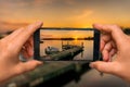 Taking photo of sunset over lake with mobile phone Royalty Free Stock Photo