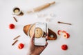 Taking photos of breakfast on phone. Composition with apple pie on white background.  Fall autumn concept. Top view, flatlay Royalty Free Stock Photo