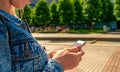 Taking picture. Happy young girl with phone smile, typing texting and taking selfie in summer sunshine urban city