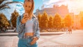 Taking picture. Happy young girl with phone smile, typing texting and taking selfie in summer sunshine urban city